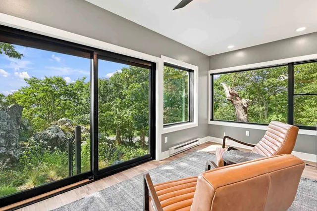 Leather lounge chair in a corner of glass overlooking the trees