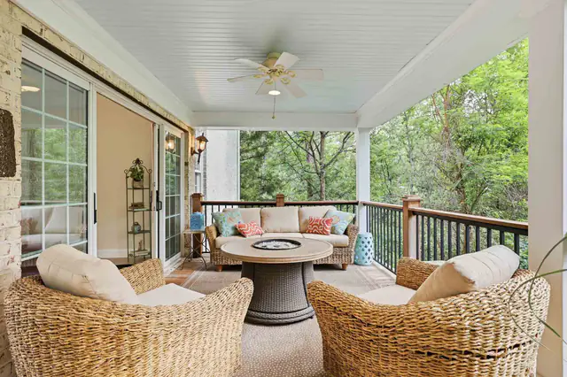 Real estate photography  -  covered porch with fire table and wooded views
