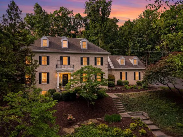 Twilight photo of a brick colonial home on a wooded hillside in Staunton VA